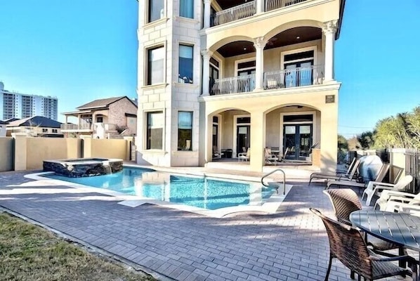 A multi-story building with a swimming pool and outdoor seating area.