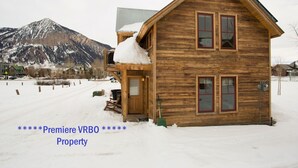 Eine Holzhütte mit Balkon und einem Berg im Hintergrund.