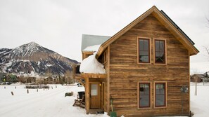 Eine Holzhütte mit Balkon und einem Berg im Hintergrund.