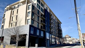 Un immeuble à plusieurs étages doté d’une architecture moderne, avec des balcons et de grandes fenêtres.
