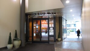 The entrance to Harbor Steps Apartments with a glass door, a reception area, and potted plants.