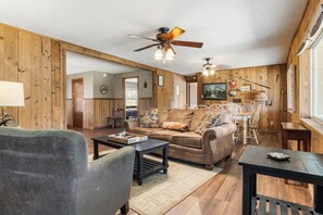A cozy living room with a sofa, a coffee table, and a dining area with a table and chairs.