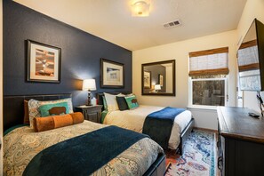 Une chambre d’hôtel avec deux lits, un grand miroir, une fenêtre avec des stores et un tapis.