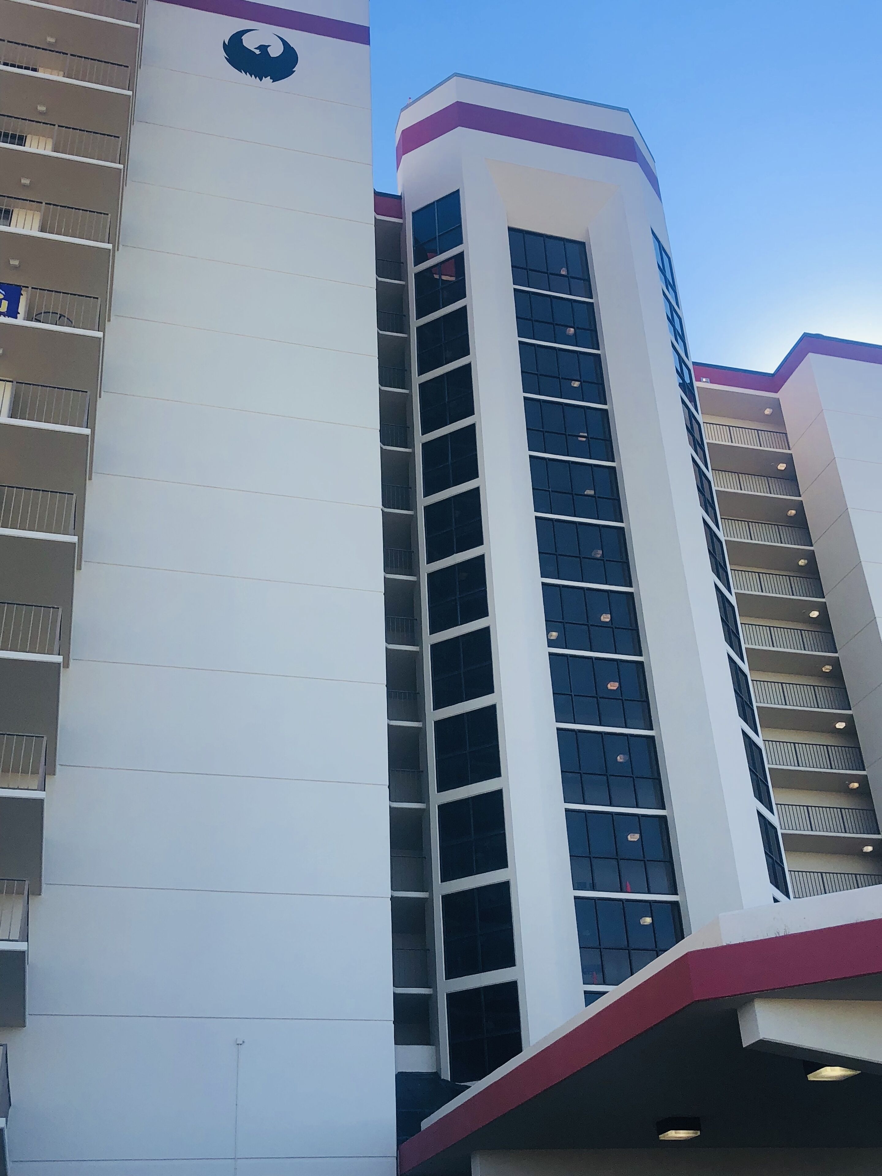 A multi-story building with a white facade and a purple accent.