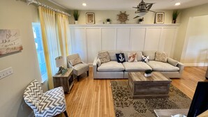 Un salon comprenant un canapé, des fauteuils, une table basse et un tapis.