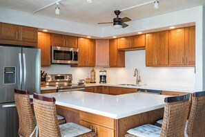 Una cocina moderna con armarios de madera, electrodomésticos de acero inoxidable y una isla grande con asientos.