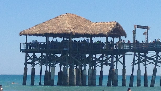 Un muelle con techo de paja y varios niveles, que se adentra en el mar.