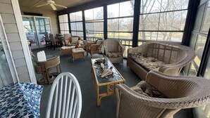 A spacious indoor area with wicker furniture, large windows, and a ceiling fan. - 3 bedroom Family Friendly condo (Lewes)
