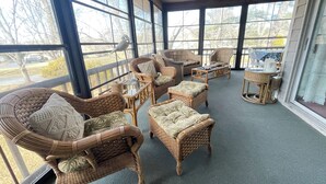 A sunlit room with wicker furniture, large windows, and a view of the outdoors. - 3 bedroom Family Friendly condo (Lewes)