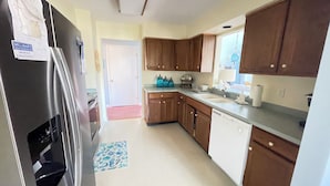 A kitchen with wooden cabinets, a stainless steel refrigerator, a dishwasher, and a sink. - 3 bedroom Family Friendly condo (Lewes)