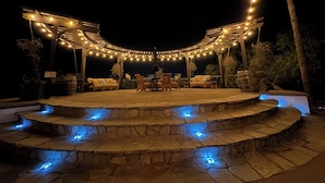 A covered outdoor patio with stone steps and string lights.