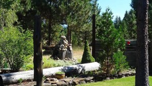 A well-maintained garden with a variety of trees, a stone wall, and a wooden fence. - Red Blanket Cabin Near Crater Lake National Park (Prospect)