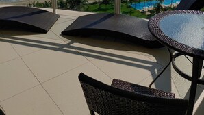 Un balcón con vistas al océano, la playa y la piscina.