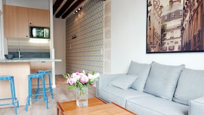 A modern kitchen with a microwave, wooden cabinets, and blue stools. - LATIN QUARTER, WOODEN BEAMS, 30–60 days ahead? Ask for a private offer. C2-VAs (Paris)