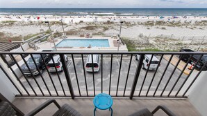 Un balcon avec vue sur une plage et une piscine.