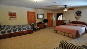 A bedroom with two beds, a ceiling fan, a television, and a mirror.