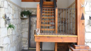 A wooden staircase with a metal railing leading to a second-floor balcony.