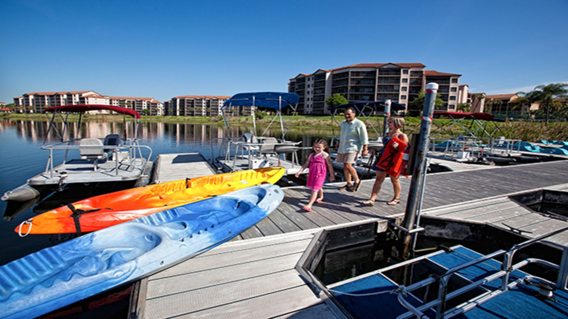 A marina with boats docked, a dock, and a building in the background.