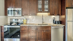 Una cocina con armarios de madera oscura, electrodomésticos de acero inoxidable y encimera de granito.