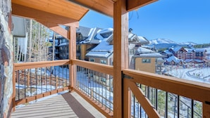 Un balcón de madera con vista a un pueblo cubierto de nieve.
