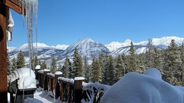 A snowy mountain landscape with a wooden cabin and a view of snow-covered peaks. - 5250 Sq Ft. 5-Star Mountain Home with 360° Peak & Valley Views (Crested Butte)