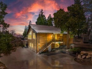 Une cabane en bois avec un toit en métal, un escalier et une véranda.