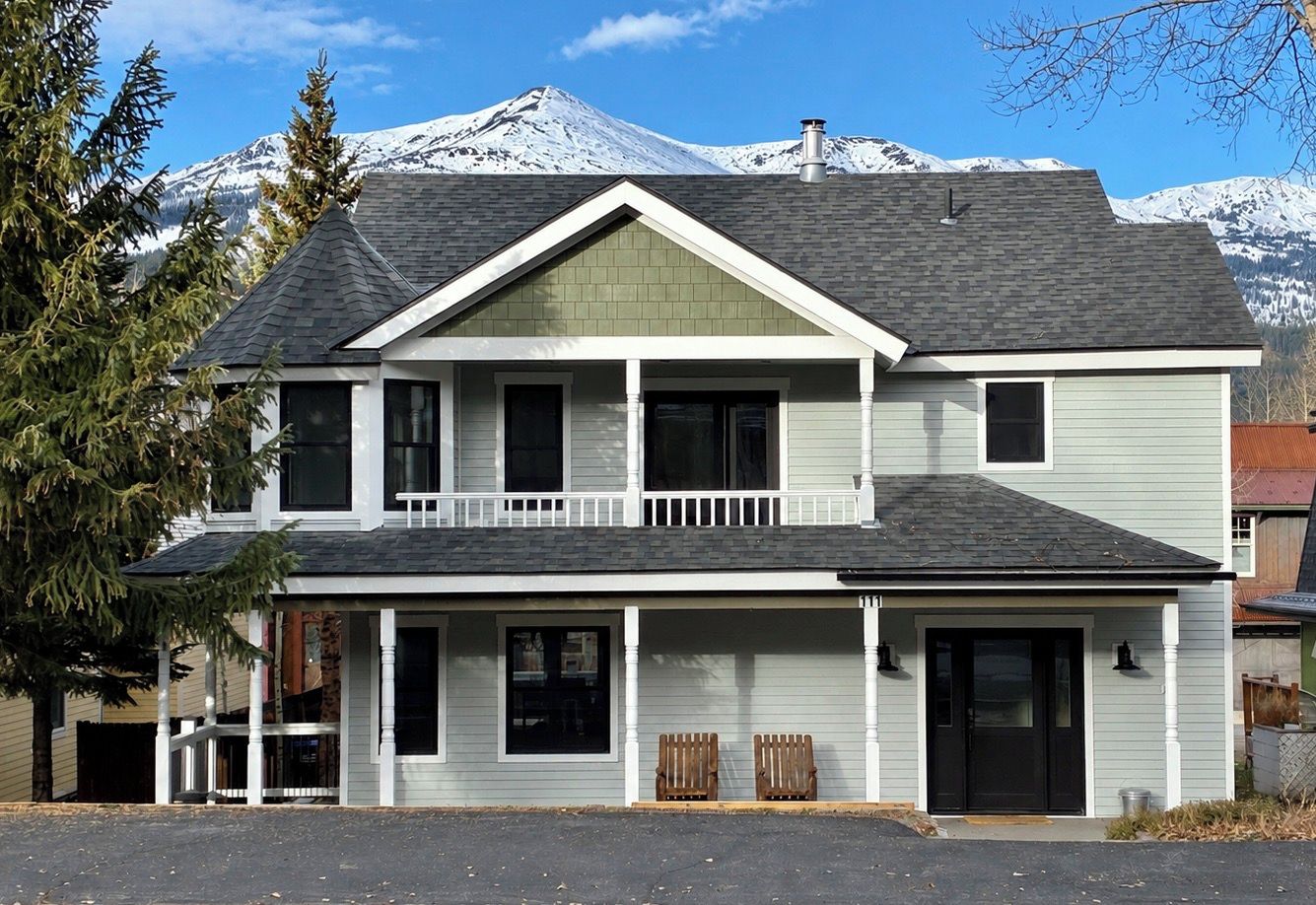 A two-story house with a balcony, a garage, and a driveway.