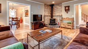 Ein Wohnzimmer mit Kamin, Fernseher und Essbereich mit Stühlen und Tisch.