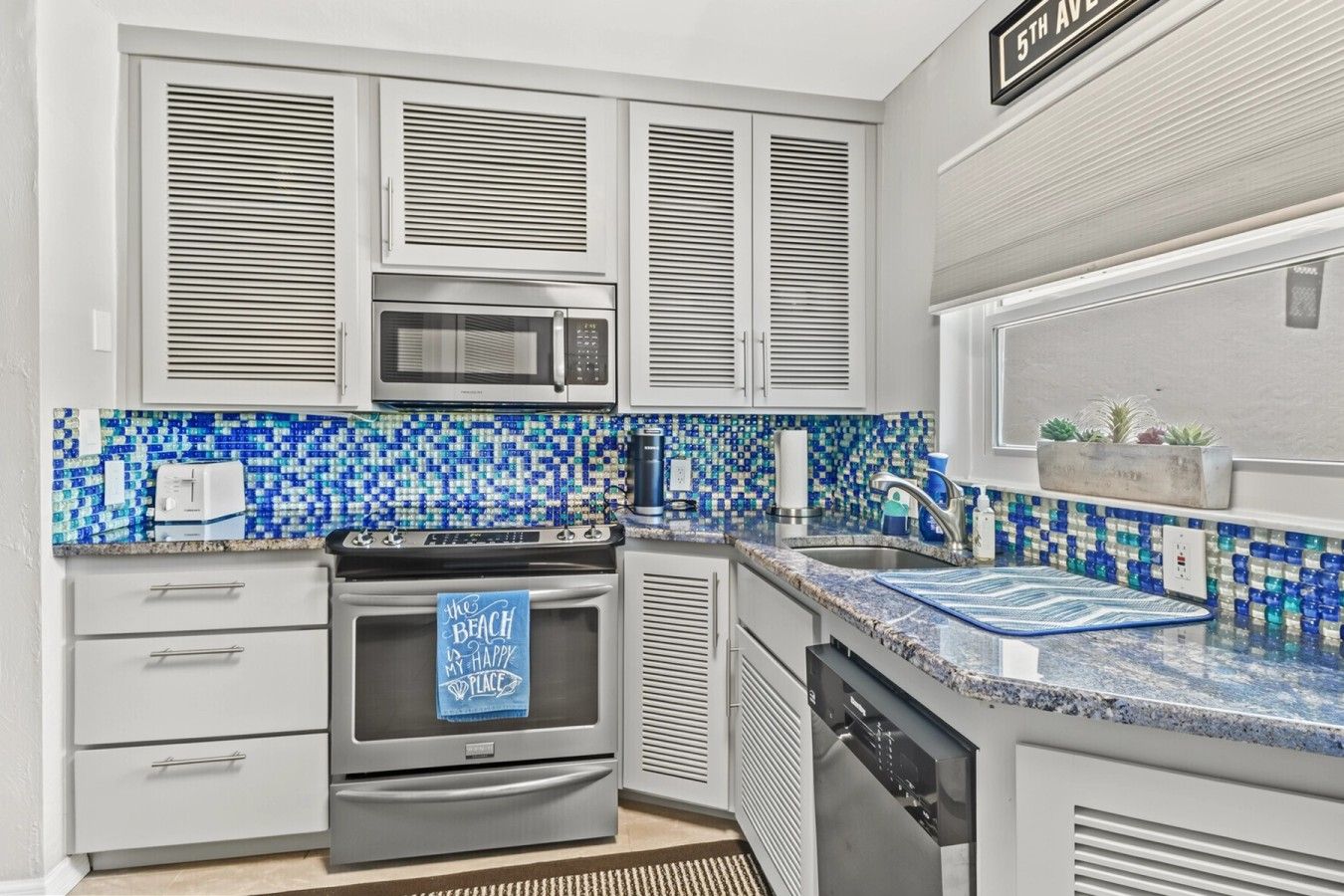 A modern kitchen with a microwave, oven, and dishwasher.