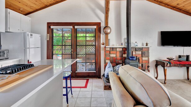Una cucina moderna con isola centrale, zona pranzo con tavolo e sedie, divano e camino.