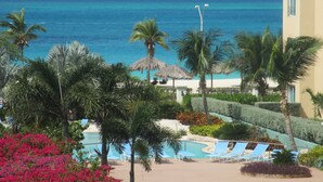 Een resort met een zwembad, palmbomen en uitzicht op de oceaan.