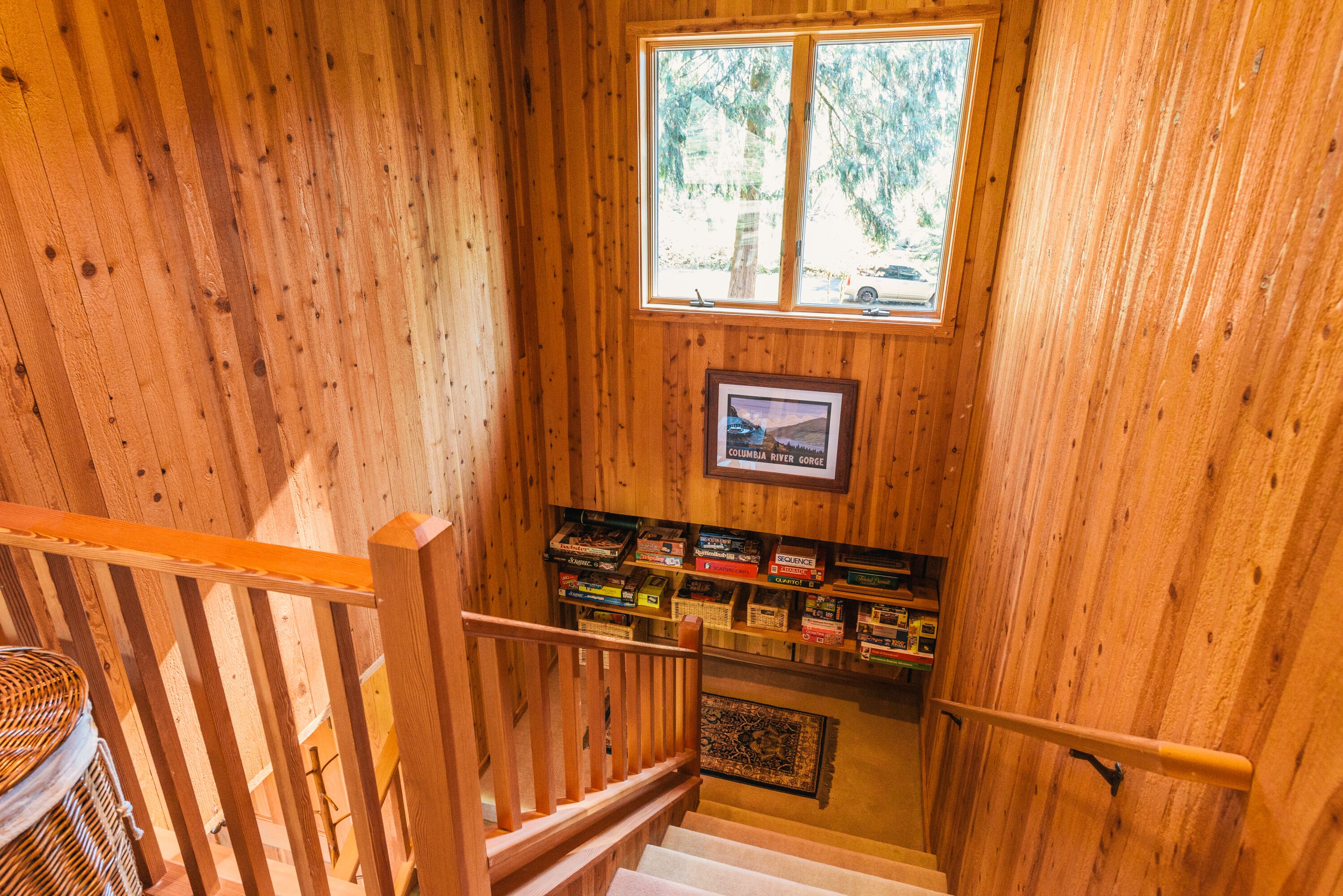 A wooden staircase with a bookshelf below.