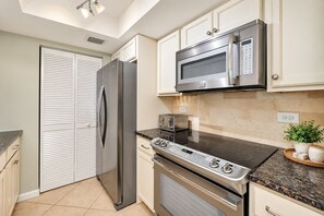 A modern kitchen with stainless steel appliances, a microwave, a toaster, and a stove.