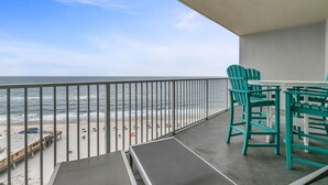 A balcony with a view of the beach and ocean.