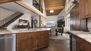 A spacious kitchen with wooden cabinets, a stainless steel dishwasher, and a large island. - 5 Claim Jumper | Ski-in/Out Chalet, Hot Tub (Big Sky)
