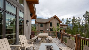 A wooden deck with outdoor seating, a fire pit, and a view of a mountain. - 5 Claim Jumper | Ski-in/Out Chalet, Hot Tub (Big Sky)