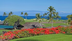 A golf course with a view of the ocean and mountains in the background.