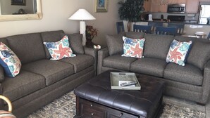 A living room with two sofas, a coffee table, and decorative pillows.