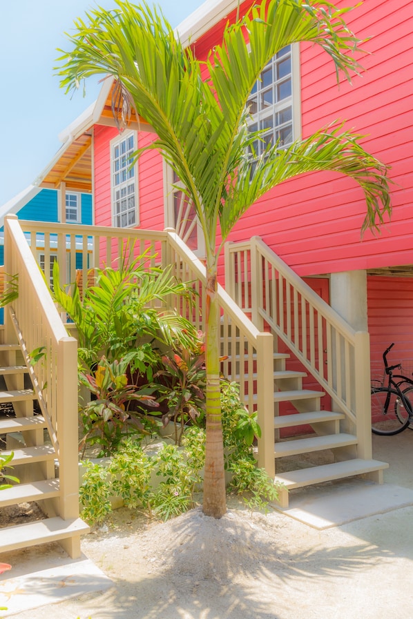Un bâtiment rouge avec un escalier et un palmier devant.