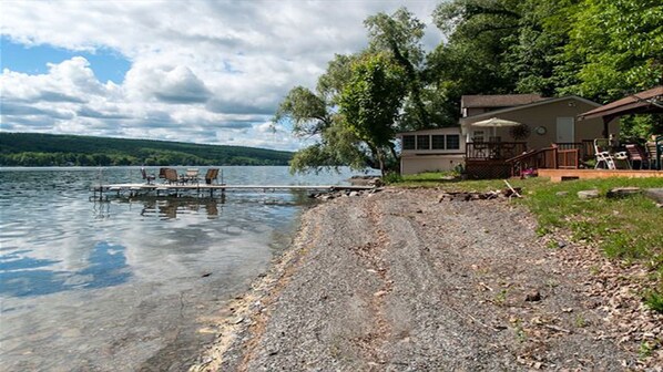 Enjoy lakeside views from the dock and main building's porch, with a deck and outdoor seating area.