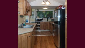 Kitchen features a microwave, sink, and stainless steel refrigerator.
