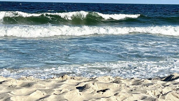 A beach with waves and sand.