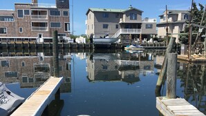 A marina with wooden docks, calm water, and residential buildings in the background.