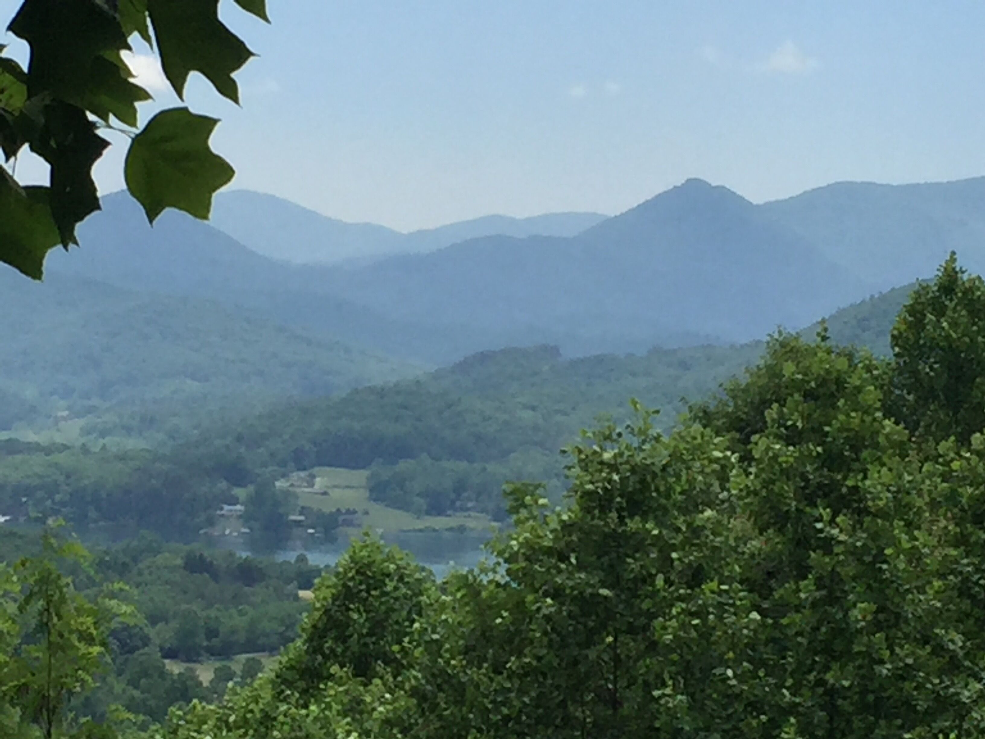 A mountainous landscape with dense greenery and a clear sky.