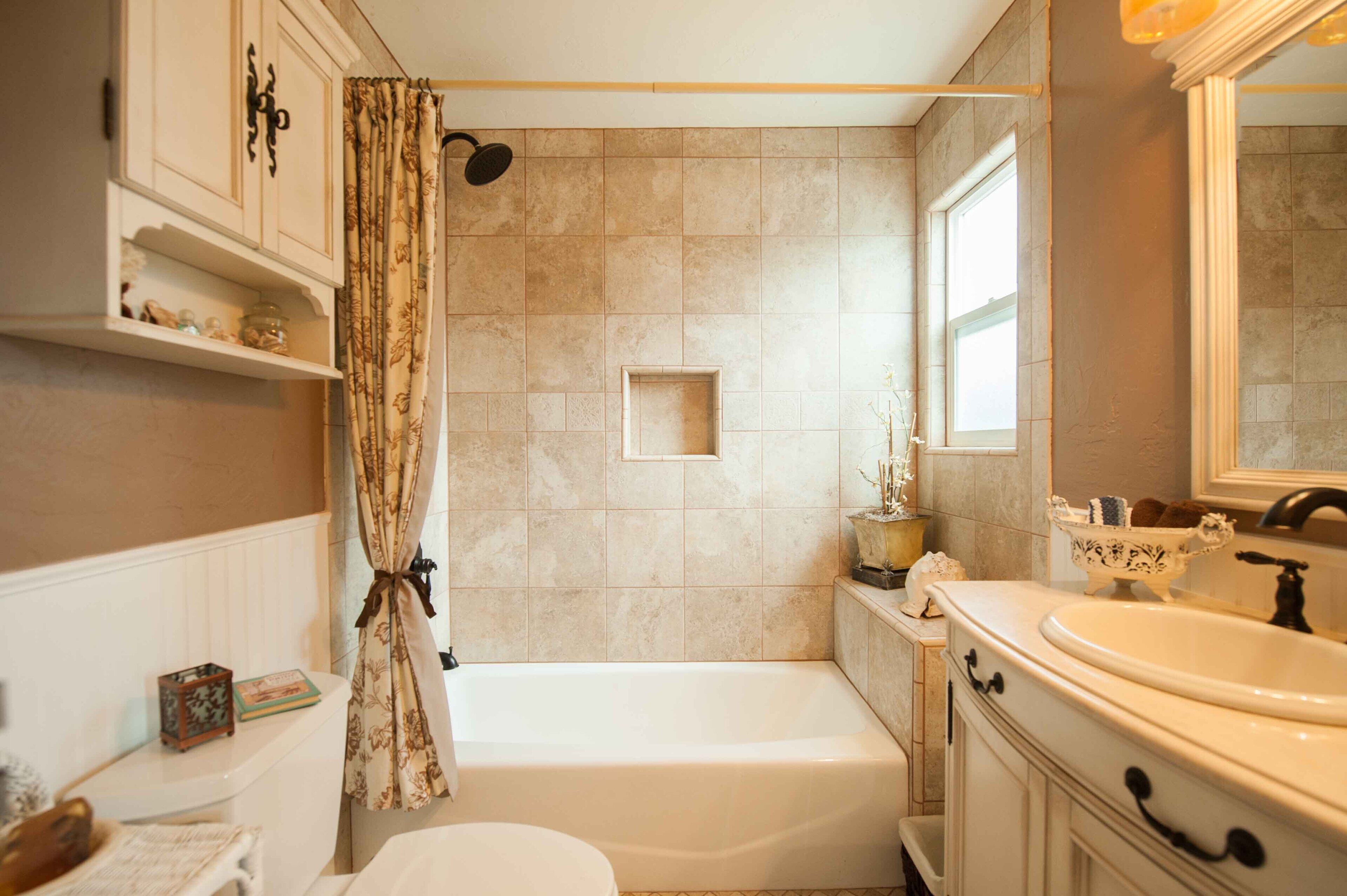 Une salle de bain avec une baignoire, un lavabo et une fenêtre.