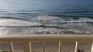 Vista de la playa con olas y cielo despejado.