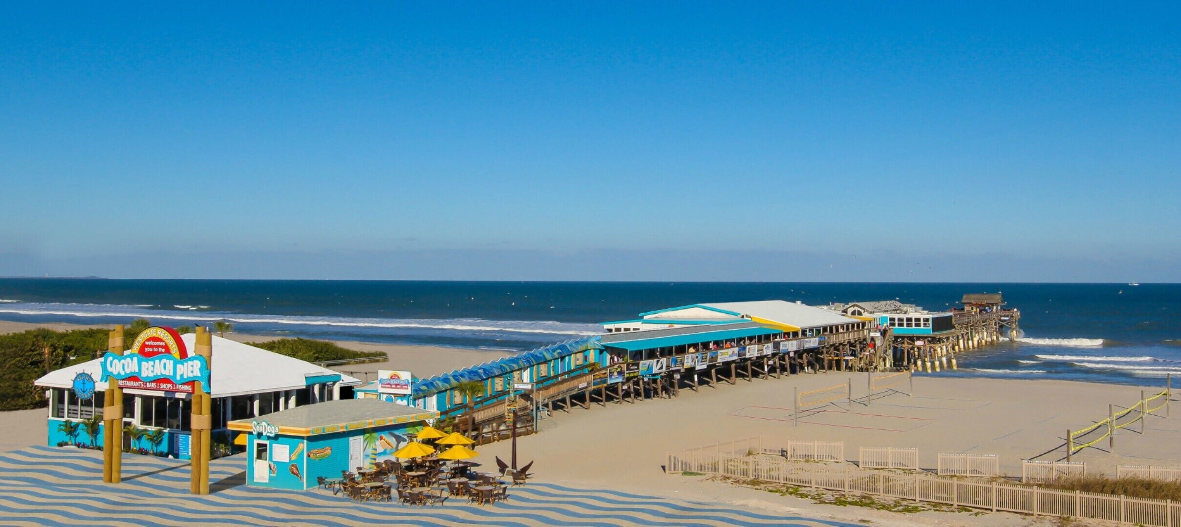 A beach pier with a restaurant named 'Cocoa Beach Pier' and a 'SeaDog' kiosk.
