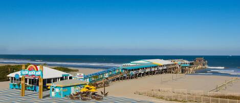 A beach pier with a restaurant named 'Cocoa Beach Pier' and a 'SeaDog' kiosk.