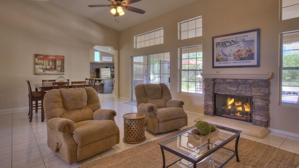 A spacious living room with a fireplace, comfortable seating, and large windows. - 4 Bedroom Single Story Golf Course Home, Heated Diving Pool + Slide, & Hot Tub  (Phoenix)