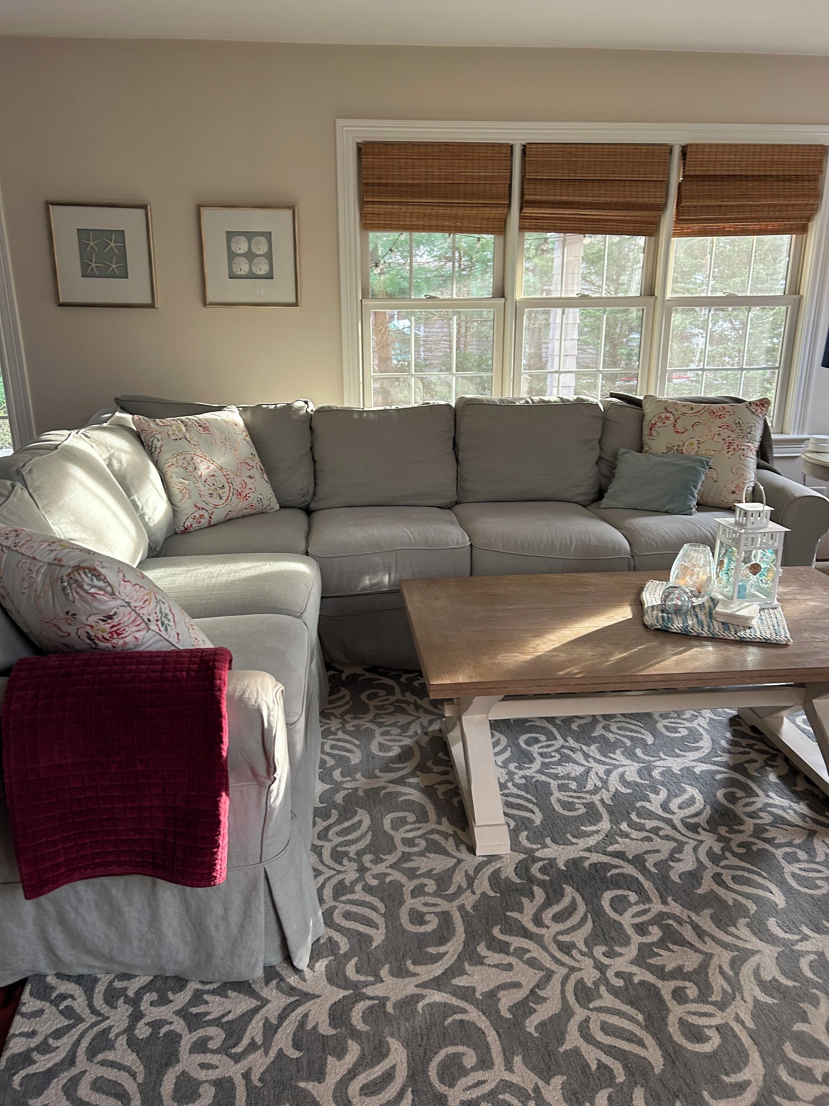 A living room with a sectional sofa, a coffee table, and a patterned rug.